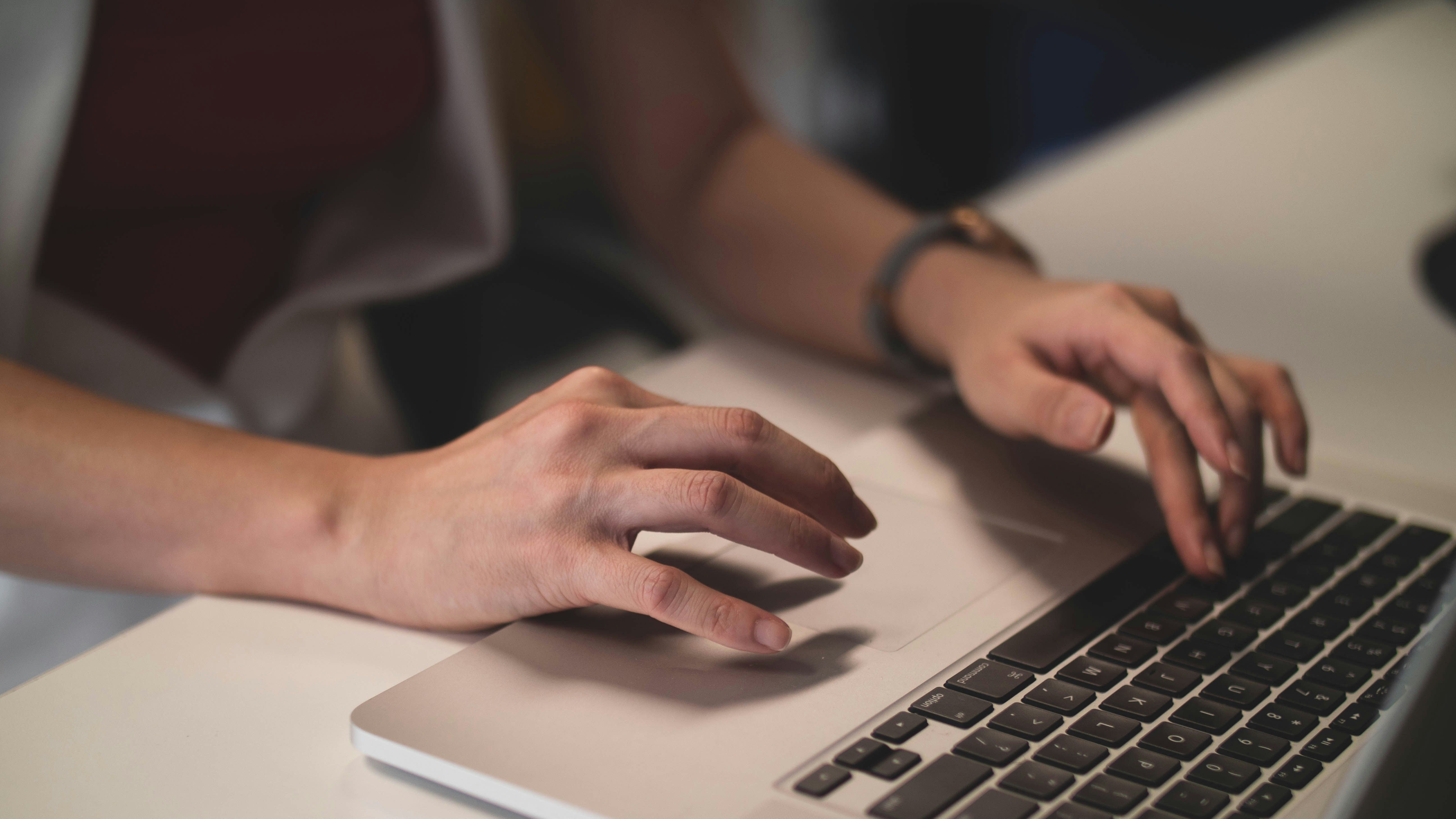 Laptop billentyűzetén gépelő kezek